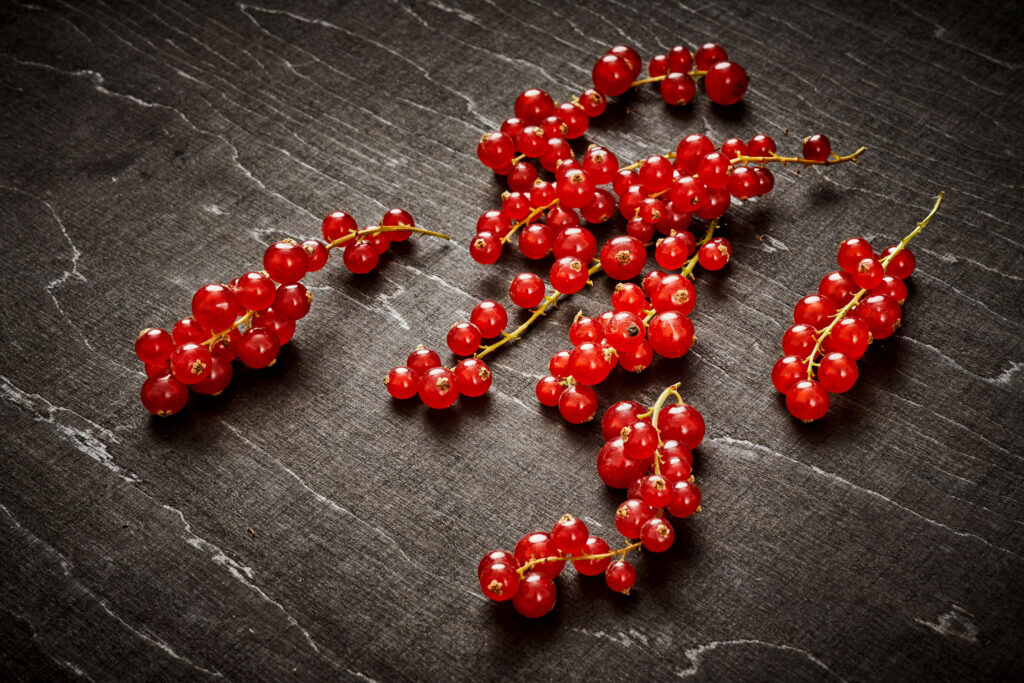delicious and juicy red currant on an old black wooden table